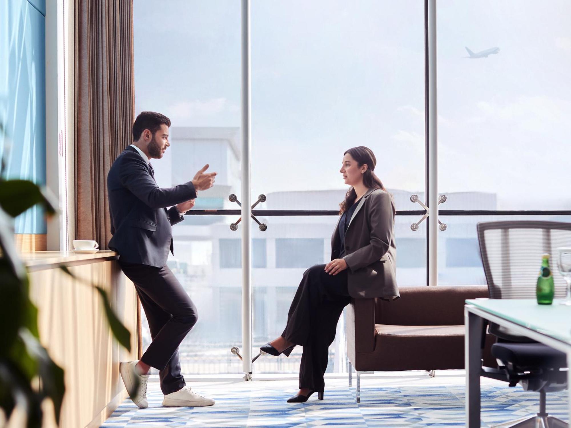 Flora Inn Hotel Dubai Airport Exterior photo Two businesspeople talking in a meeting